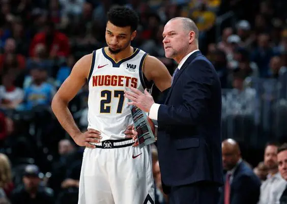 Head coach of the Nuggets explaining his player the game strategy